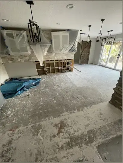Living room with the flooring pulled up and containment plastic during a dry-out