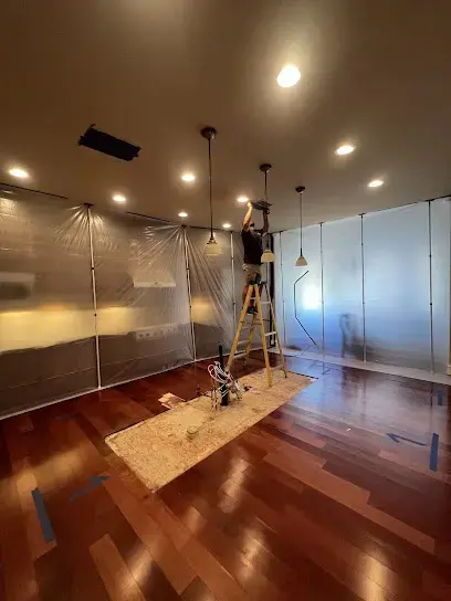 Technician working inside containment above a wood floor in a large room