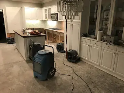 Dehumidifier and air movers drying an open kitchen in a Newport Beach home